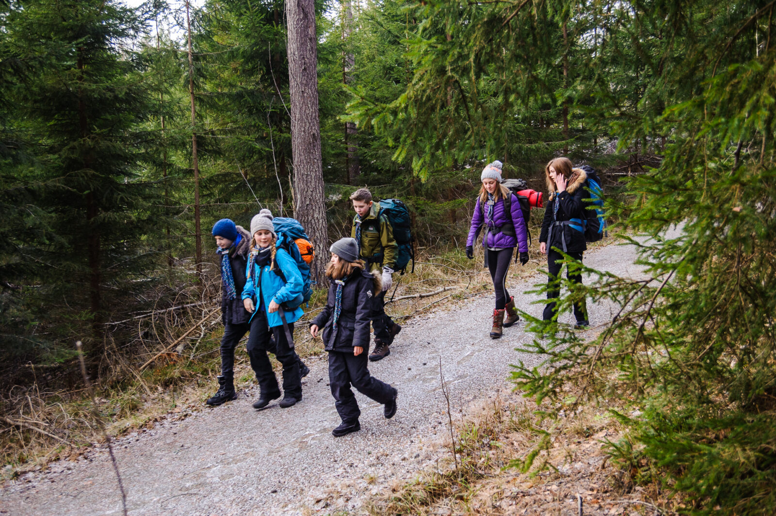 Speidere på tur i skogen med tunge sekker
