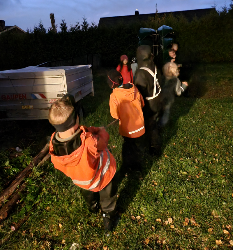 Speidere som spiller drakamp utendørs i mørket med refleksvester